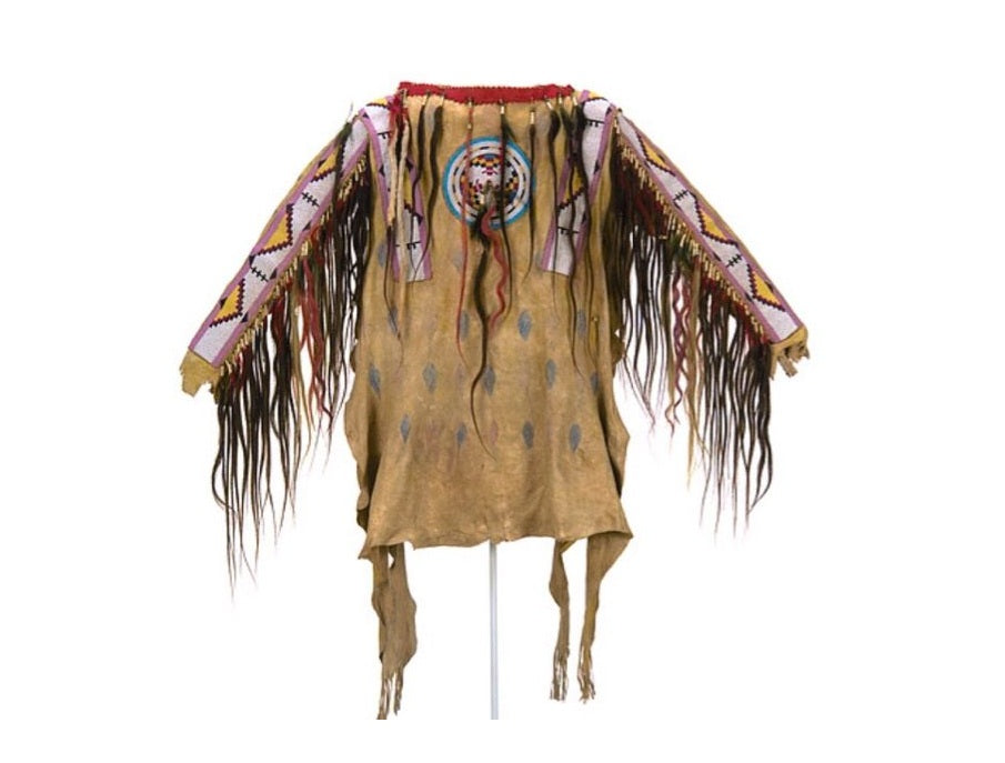 Traditional Native American garment with fringes and patterns on a white background