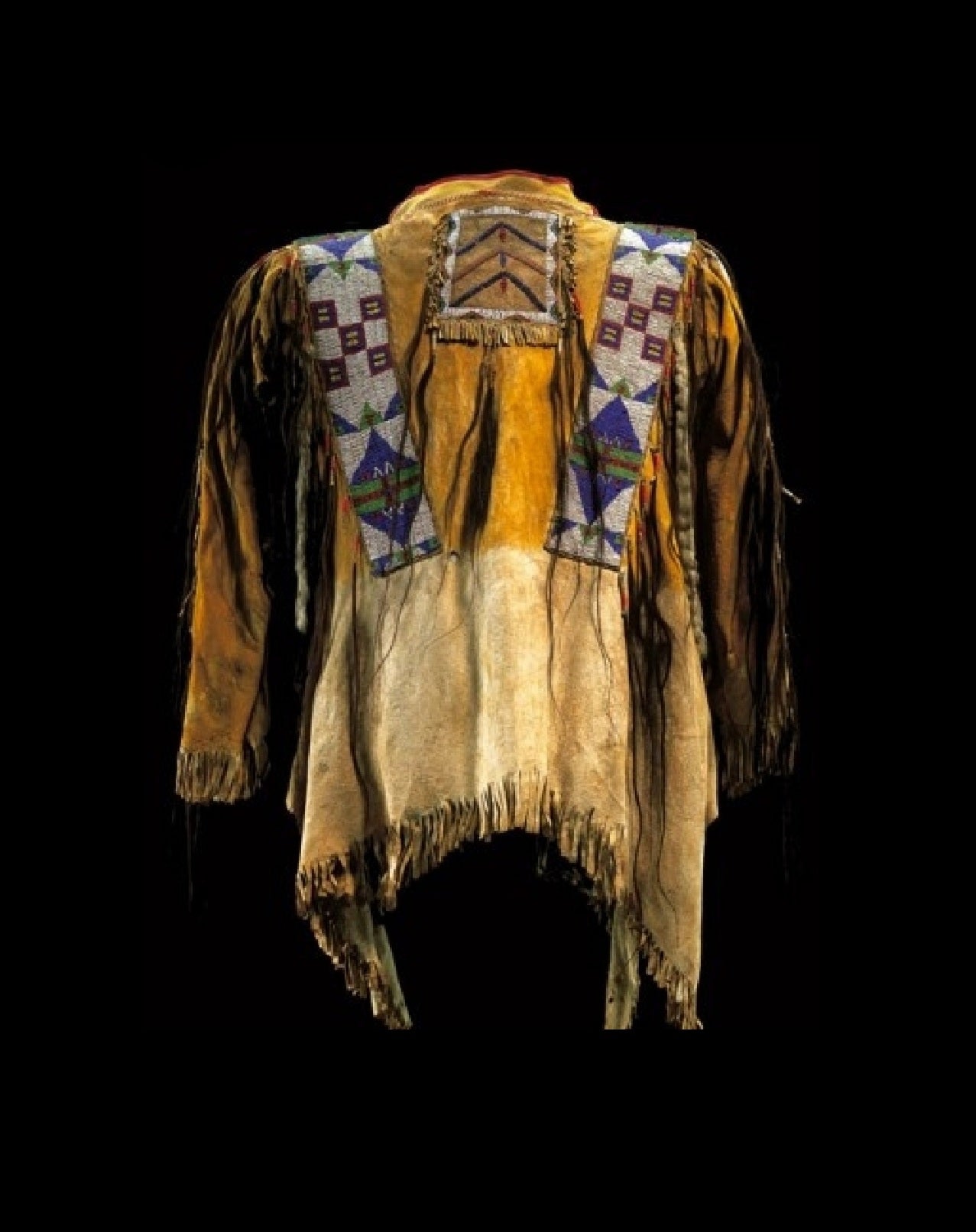 Traditional Native American garment with intricate patterns and fringes on a black background