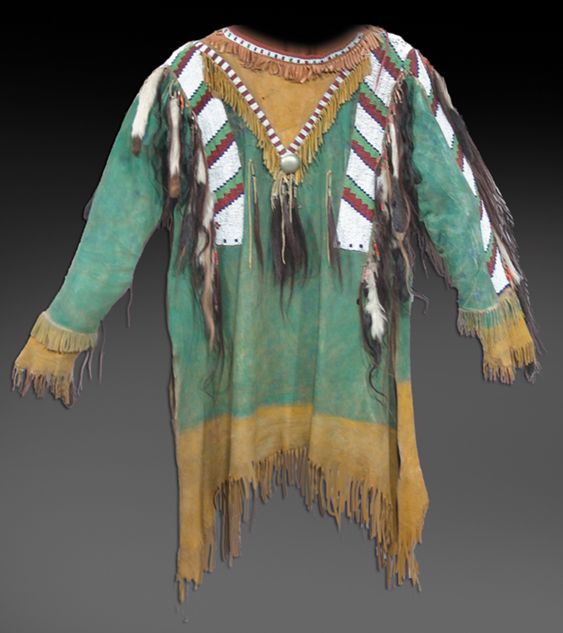 Traditional Native American garment with fringes and patterns on a gray background